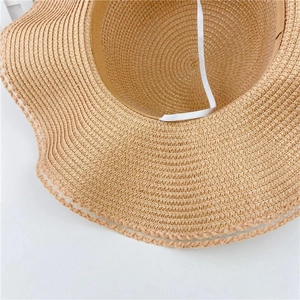 Detailed close-up of straw sun hat weaving and adjustable white elastic wind strap