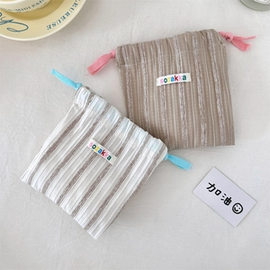 Close-up of vertical stripe drawstring organizer bags with cotton linen texture and fabric label