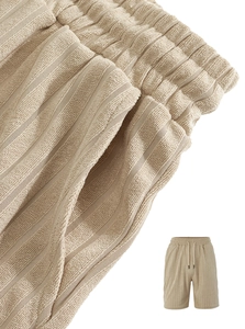 Dettaglio ravvicinato di pantaloncini beige da uomo con trama a righe e cordoncino in vita