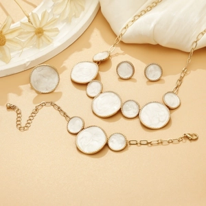 Detail of gold-plated white enamel jewelry set with necklace, bracelet, earrings and ring