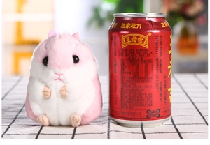 Kleiner rosa Plüschhamster Anhänger neben einer Getränkedose zum direkten Größenvergleich