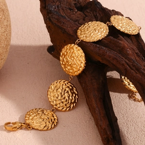 Dettaglio del bracciale placcato oro 18K con texture a spirale martellata sui dischi tondi