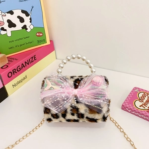 Kids plush leopard bag with pink bow, pearl handle, and gold chain strap in life scene