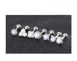 Detail view of 925 sterling silver mini pearl stud earrings set with screw back design
