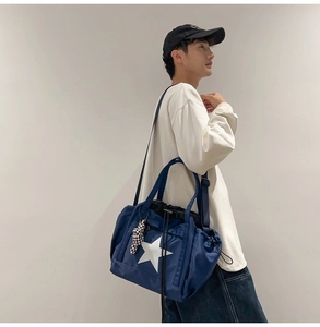 Detail of navy blue nylon crossbody bag with white star print and drawstring closure