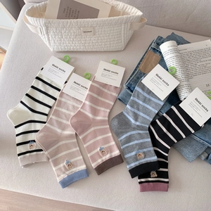 Détail de chaussettes en tricot rayées avec broderie ours et poignets côtelés en plusieurs coloris