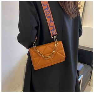 Detail of caramel brown quilted bag with chunky resin chain and printed wide strap