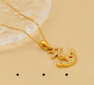 Detailed close-up of a gold-plated stainless steel anchor pendant with zircon accents
