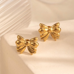 Elegant gold bow-shaped titanium steel stud earrings on a geometric display stand