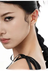 Dettaglio del ear cuff dorato a doppio strato e argentato a strato singolo sull'orecchio