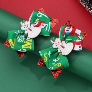 Close-up of Christmas snowman hair clips with green rib ribbons and red glitter stars
