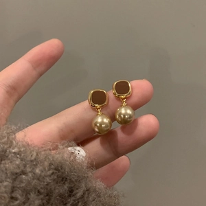 Detail of vintage square brown enamel stud earrings with gold imitation pearls