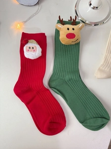 Detail of cotton Christmas socks with 3D plush Santa and reindeer decorations
