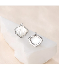 Macro shot of S925 silver ginkgo leaf stud earrings with white shell and zircon inlay