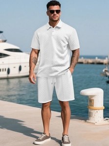 Detail of white waffle texture polo shirt and matching shorts on a summer yacht