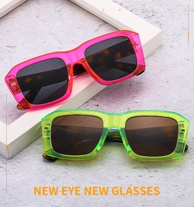 Detail view of retro square chunky sunglasses in translucent pink and neon green frames
