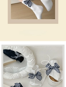 Detail of grey cotton crew socks with plaid gingham bow accent in a cozy lifestyle setting