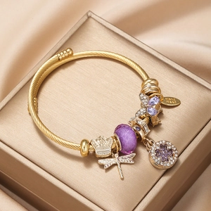 Golden butterfly and clover charm bracelet with purple glass beads on silk