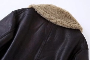 Détail de la texture en similicuir et du col en peau de mouton sur veste aviateur