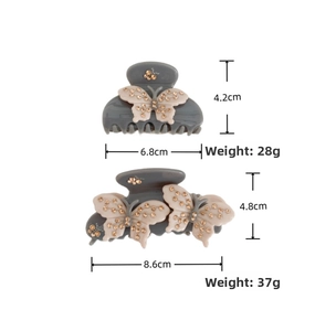 Detail view of two sizes of gray shark clips with pink crystal bow accents and dimensions