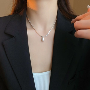 Polished silver teardrop pendant necklace on double blade snake chain worn by a model