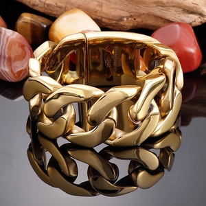 Close-up of golden Cuban link chain with Stainless Steel 316L hallmark on black surface