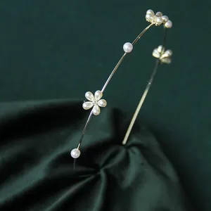 Dettaglio dell'elegante cerchietto dorato con perle e decorazioni floreali in cristallo