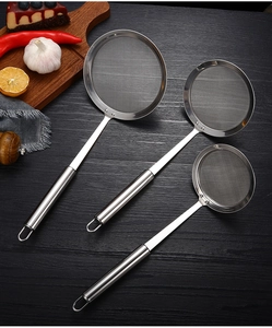Set of three stainless steel mesh strainers in various sizes on dark wood background