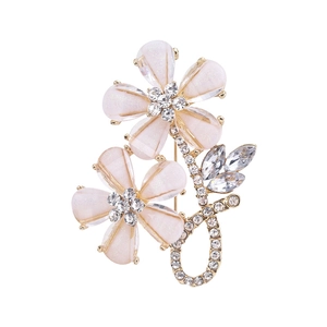 Detail of floral brooch with pink enamel petals and sparkling rhinestones on gold base