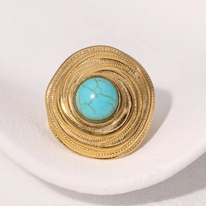 Gros plan d'une bague vintage en or 18k avec turquoise et texture spirale