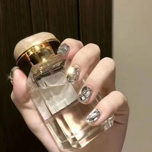 Detail of silver glitter press-on nails with sparkling diamond rhinestones and luxury finish