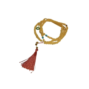 Long collier de perles chinoises avec perles en résine jaune et pompon en soie rouge