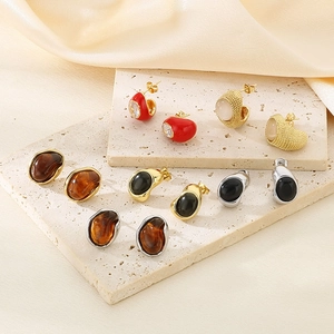 Macro shot of vintage amber and cat eye earrings displayed on textured stone blocks