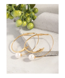 Detail view of S925 sterling silver hoop earrings with white pearls on a stone background