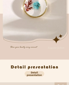 Detail view of round gold alloy pendant with red and blue dried flowers in clear resin