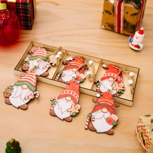 Set of six wooden Christmas gnome ornaments with red hats in a storage box on a wooden desk