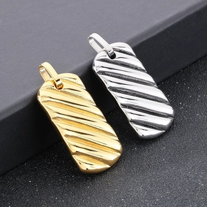 Macro detail of rectangle bar pendants with textured wave patterns in gold and silver