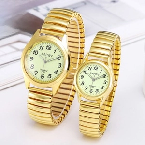 Detail of gold quartz couple watches with green dials and elastic stainless steel bands