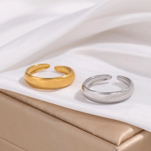Minimalist adjustable open rings in gold and silver finish on silk fabric background