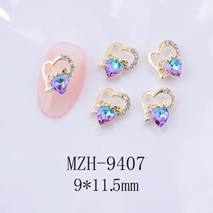 Détail de bijoux d'ongles en cœur 3D avec pierres dégradées violettes et strass blancs