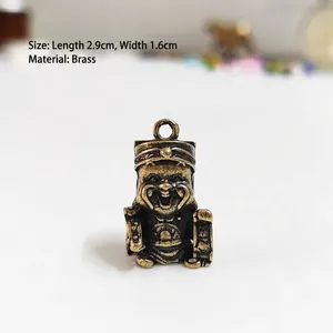 Vue macro détaillée d'un pendentif Dieu de la Richesse en laiton de 2,9cm x 1,6cm