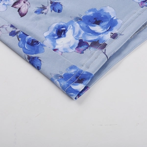 Detailed close-up of blue floral dress showing high-quality stitching and fabric texture