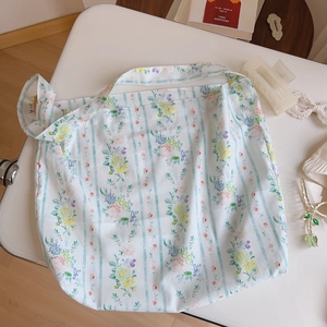 Flat lay of a floral canvas tote bag with blue stripes and delicate flower patterns