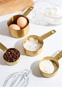 Macro shot of gold stainless steel measuring cups with engraved capacity markings