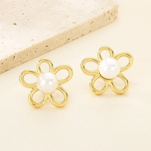 Détail de boucles d'oreilles fleurs ajourées plaquées or 18K avec perle blanche