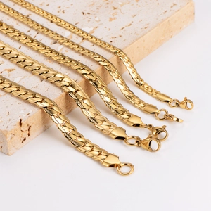 Five assorted gold stainless steel flat dragon chains with lobster clasps on stone