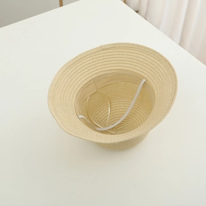 Detailed interior of woven straw hat showing sweatband and elastic chin strap