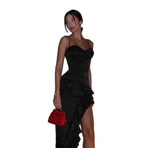 Détail de la robe en satin noir avec une fente haute et des ornements de volants superposés