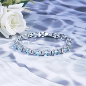 Silver bracelet with oval blue gemstones and pavé diamonds on silk with white roses