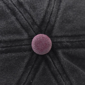 Detailed macro view of the dark grey cotton baseball cap crown with red top button